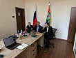 Рабочая встреча за столом с ноутбуками и символикой «Урожая»