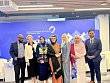 Группа людей у фиолетового стенда фестиваля